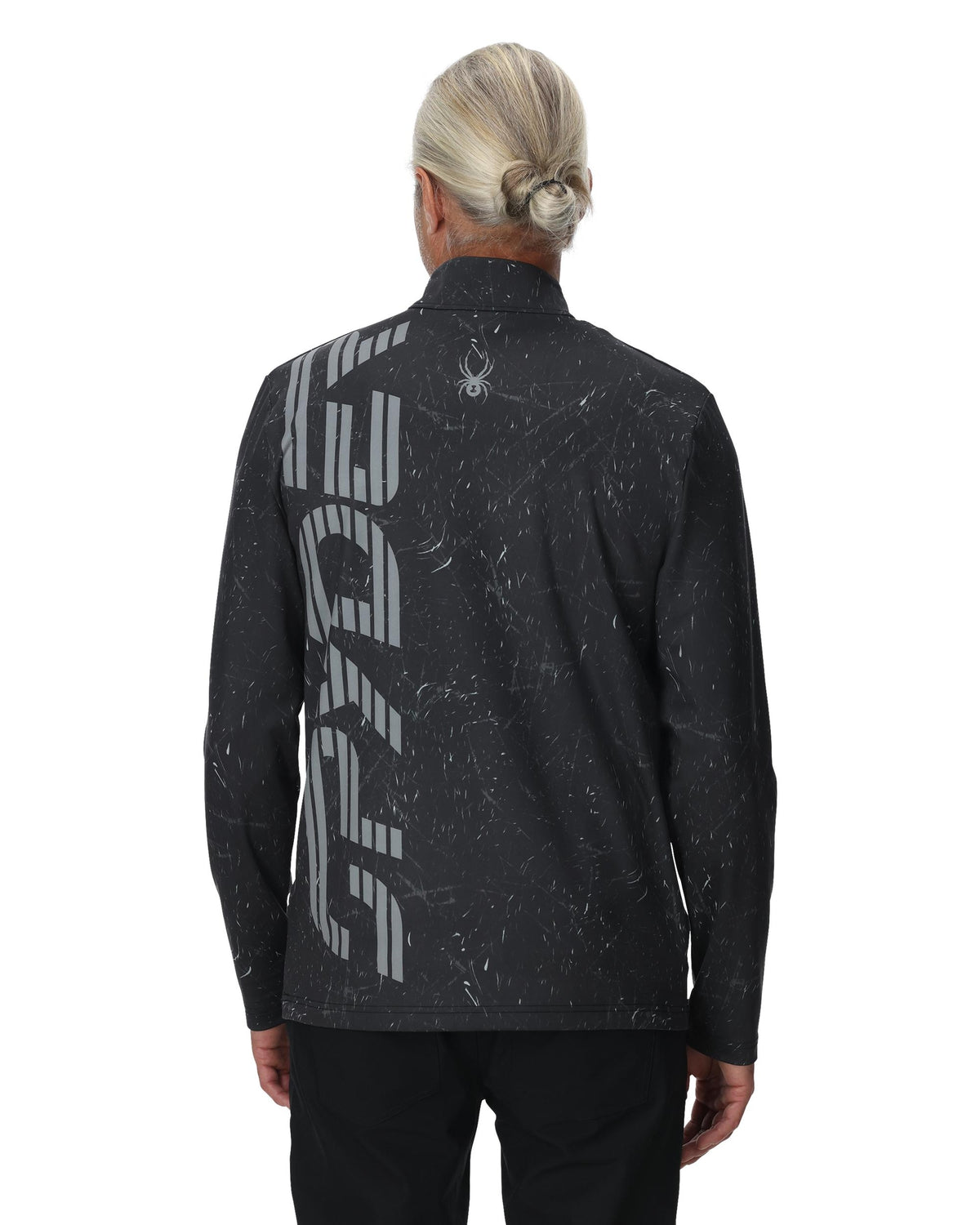 Person wearing a black athletic jacket with branding on the back against a white background