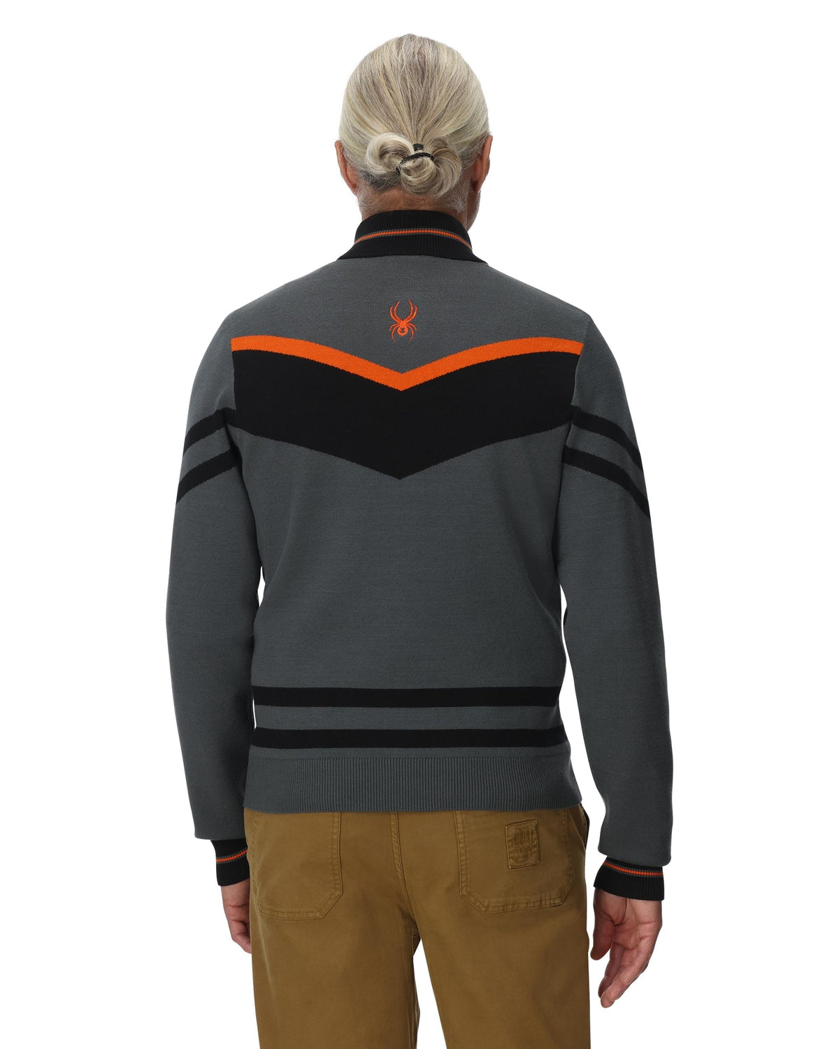 Person wearing a gray and black jacket with orange accents on a white background