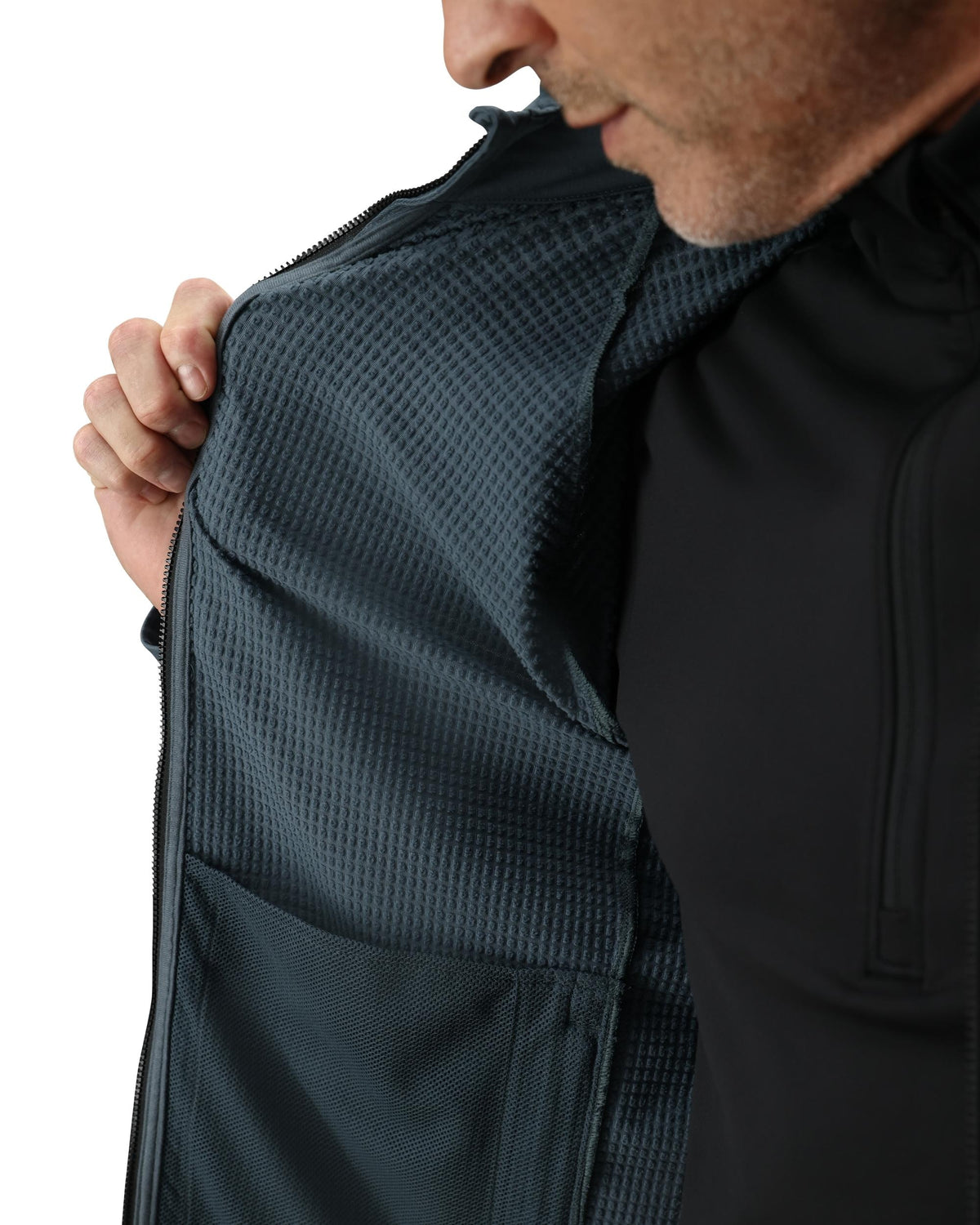 Person wearing a dark jacket with a textured pattern on a white background