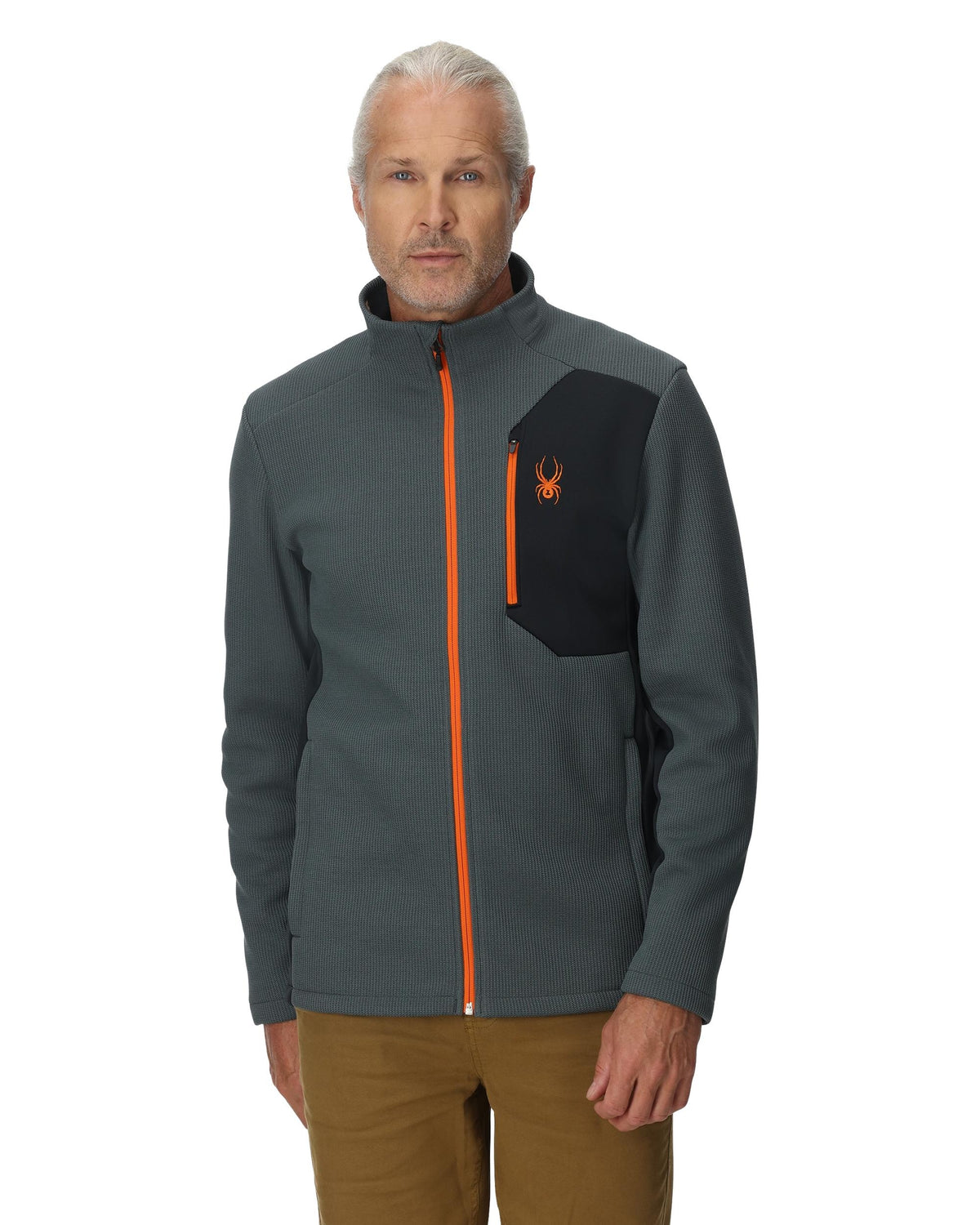 Man wearing a gray jacket with an orange zipper and logo on a white background