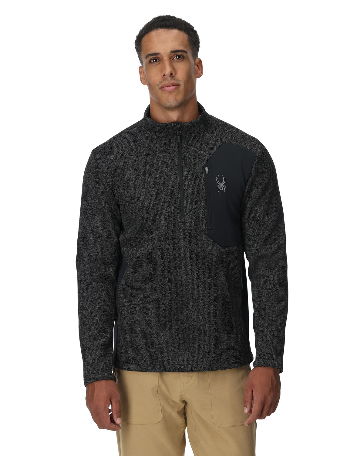 Man wearing a dark gray pullover with a logo on a white background