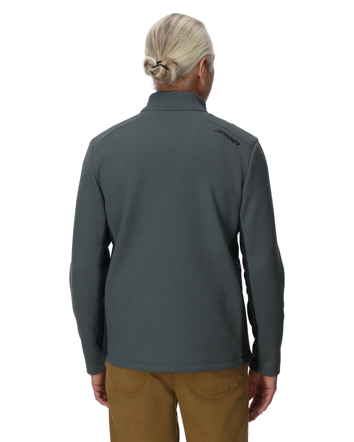 Person wearing a gray pullover with a brand logo on the back, standing against a white background