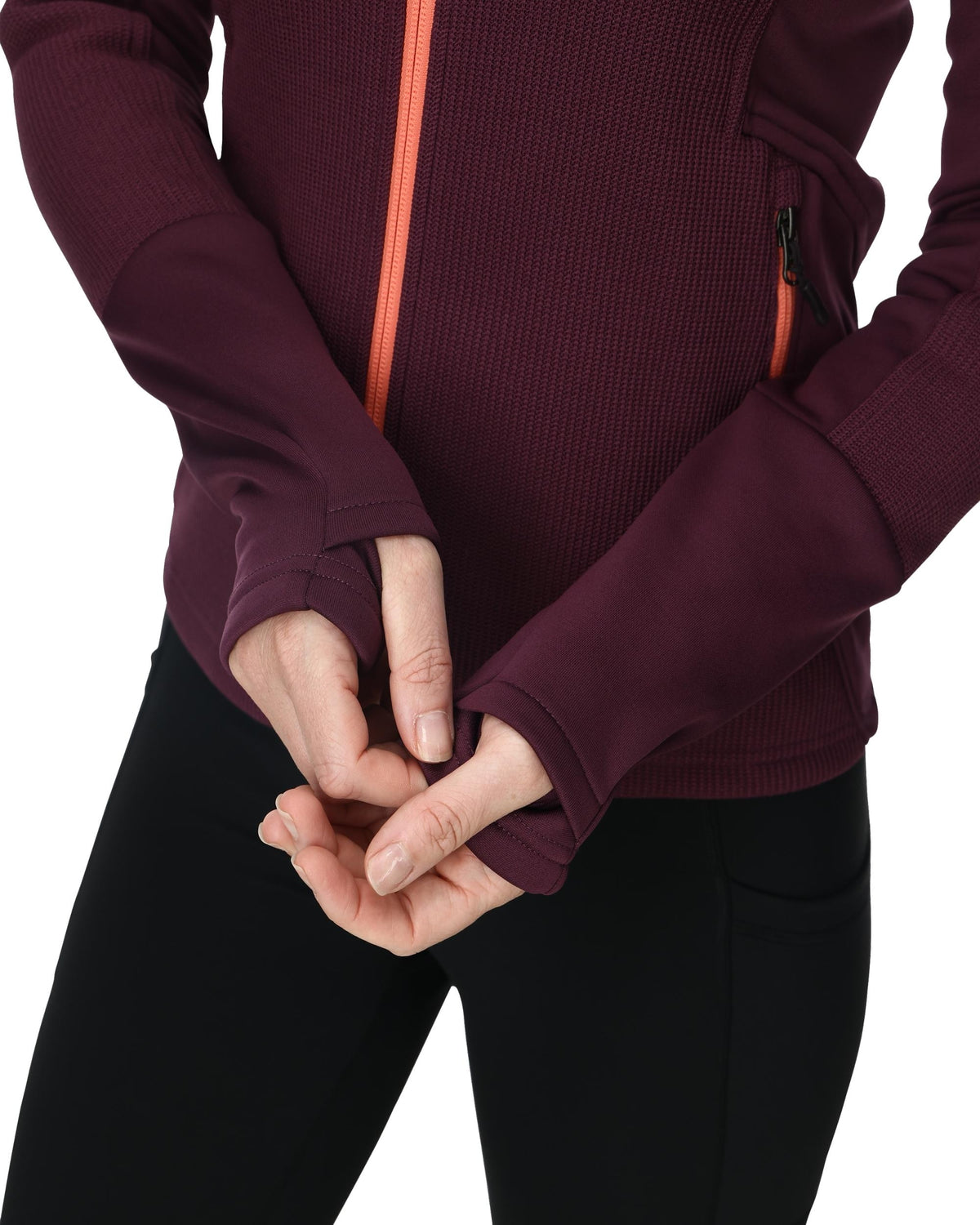 Close-up of a person wearing a maroon jacket with a zipper, holding their hands together.