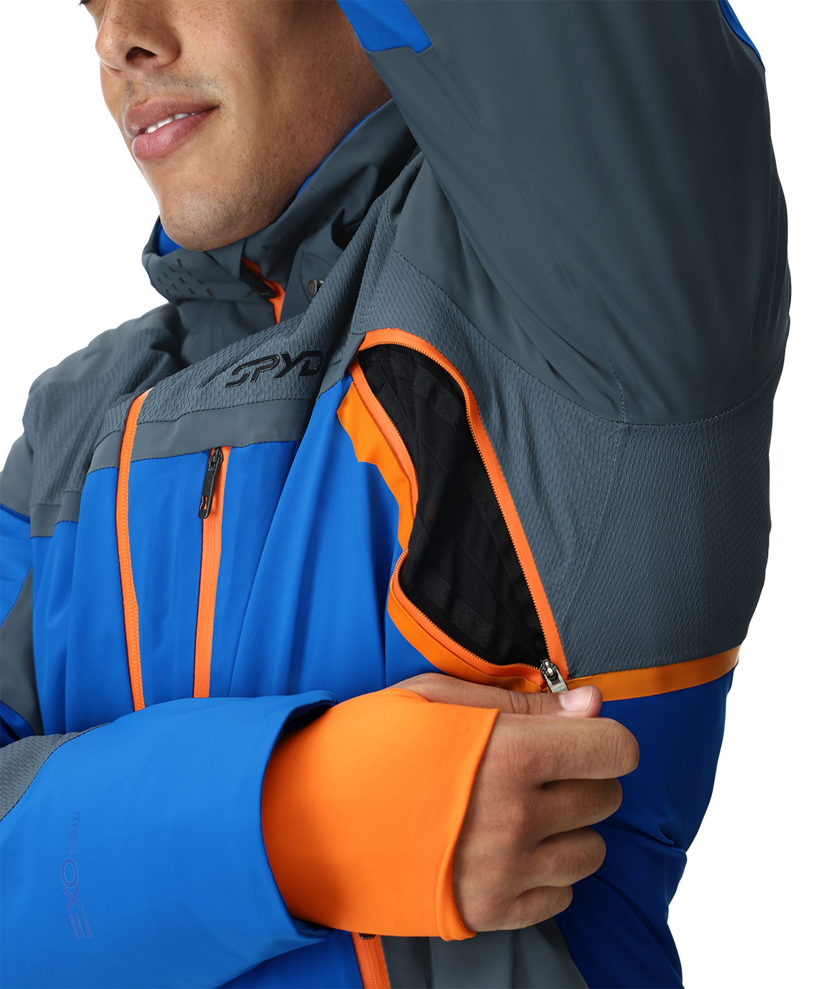 Person wearing a blue and gray jacket with orange accents, featuring the Spyder brand.