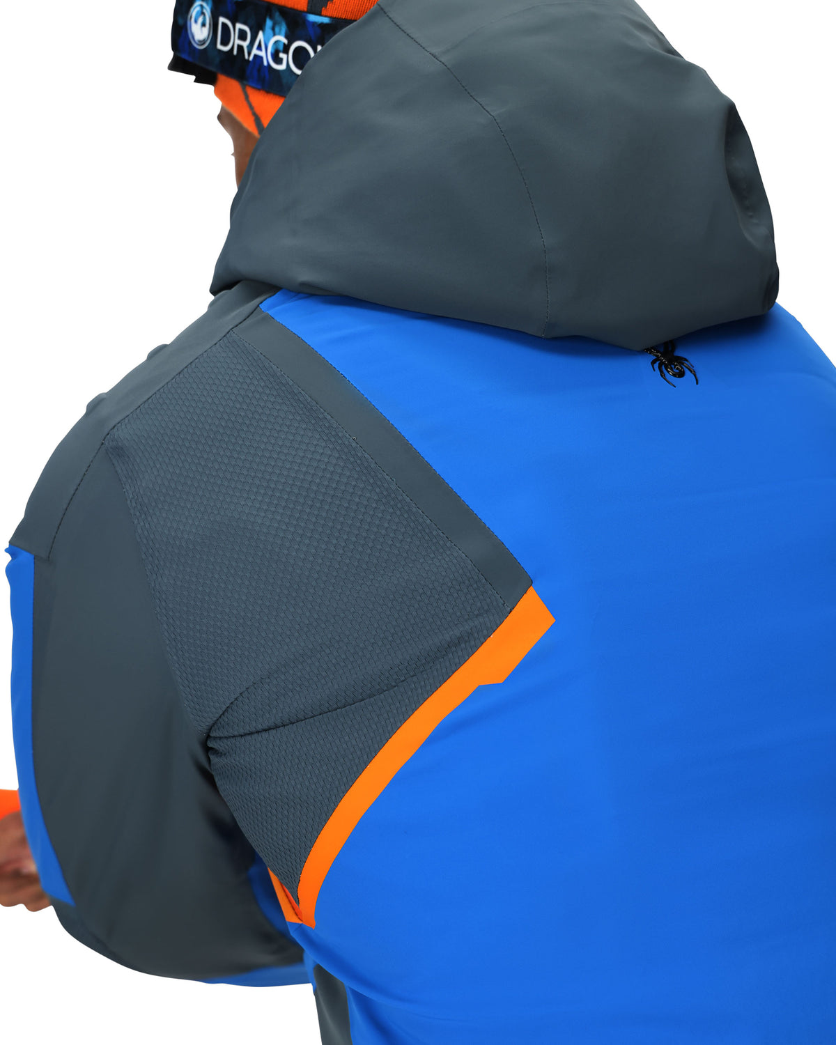 Person wearing a blue and gray jacket with orange accents on a white background