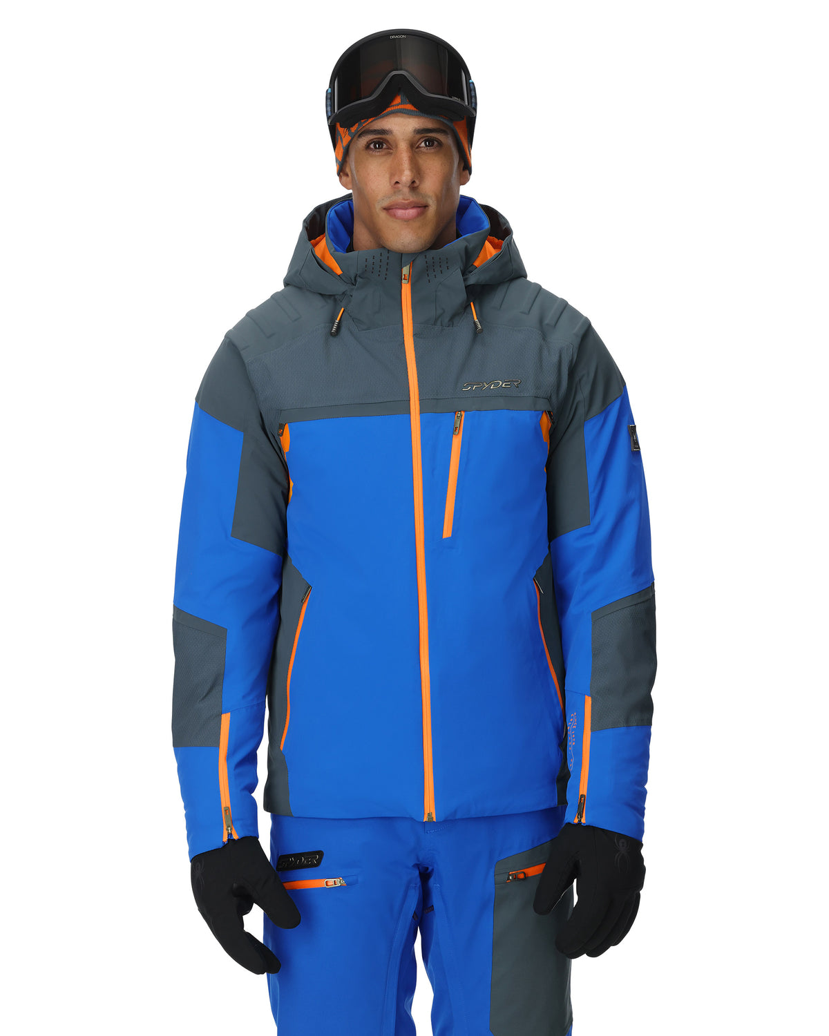Person wearing a blue and gray ski jacket with orange accents on a white background