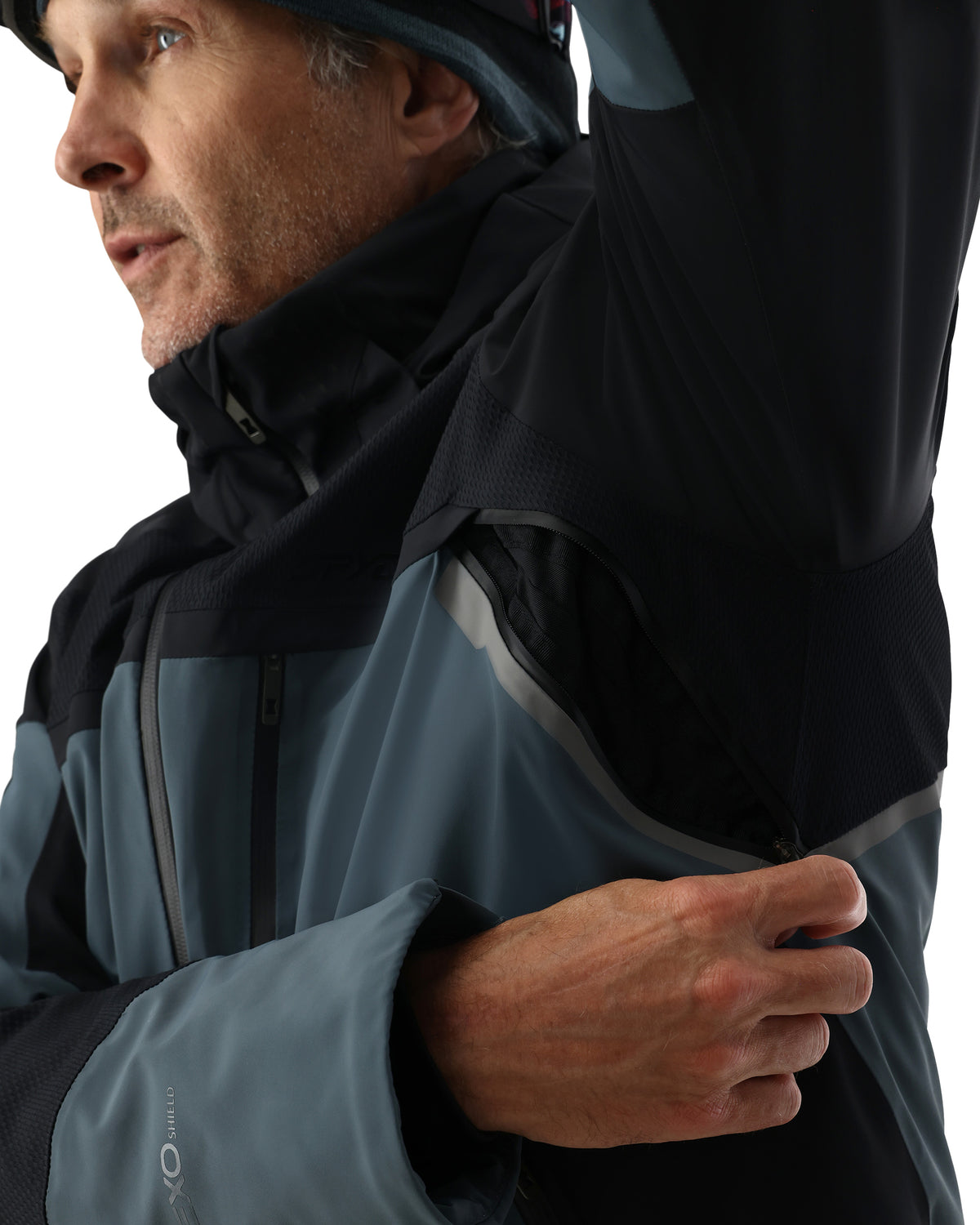 Person wearing a black and gray jacket with a hood, looking to the side.