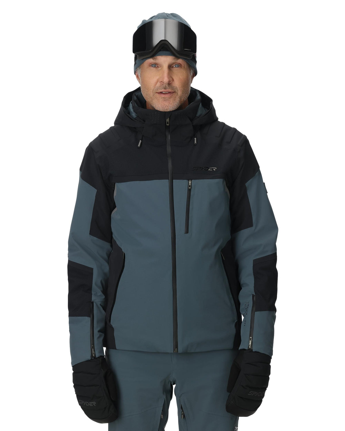 Man wearing a black and gray ski jacket with goggles on a white background
