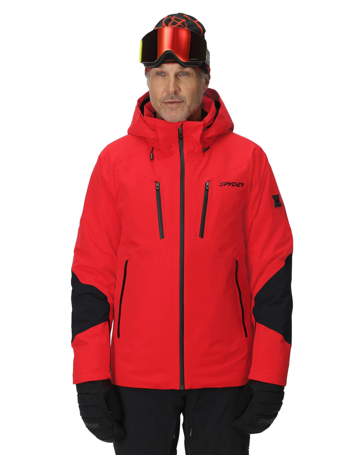 Person wearing a red and black ski jacket with goggles on a white background