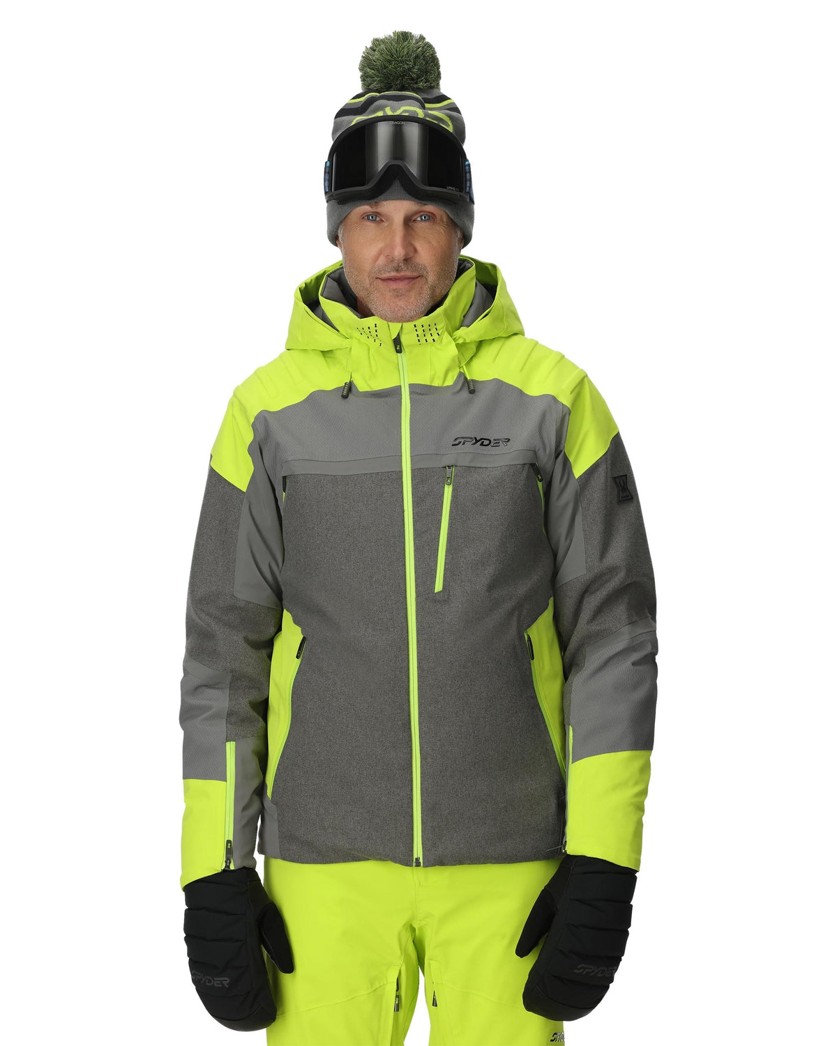 Person wearing a gray and neon green ski jacket with goggles on a white background