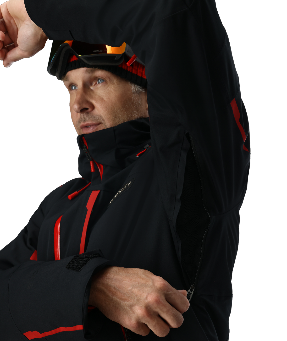 Man wearing a black jacket with red accents and goggles on his head against a white background