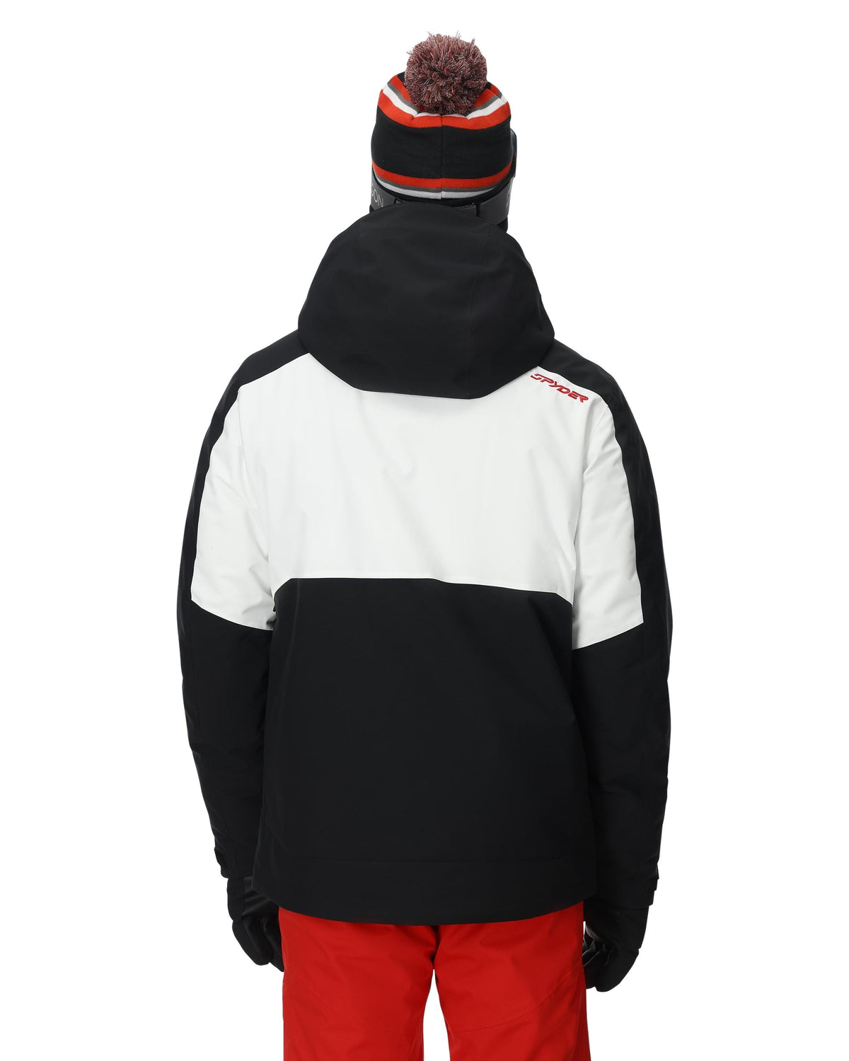 Person wearing a black and white jacket with red pants on a white background