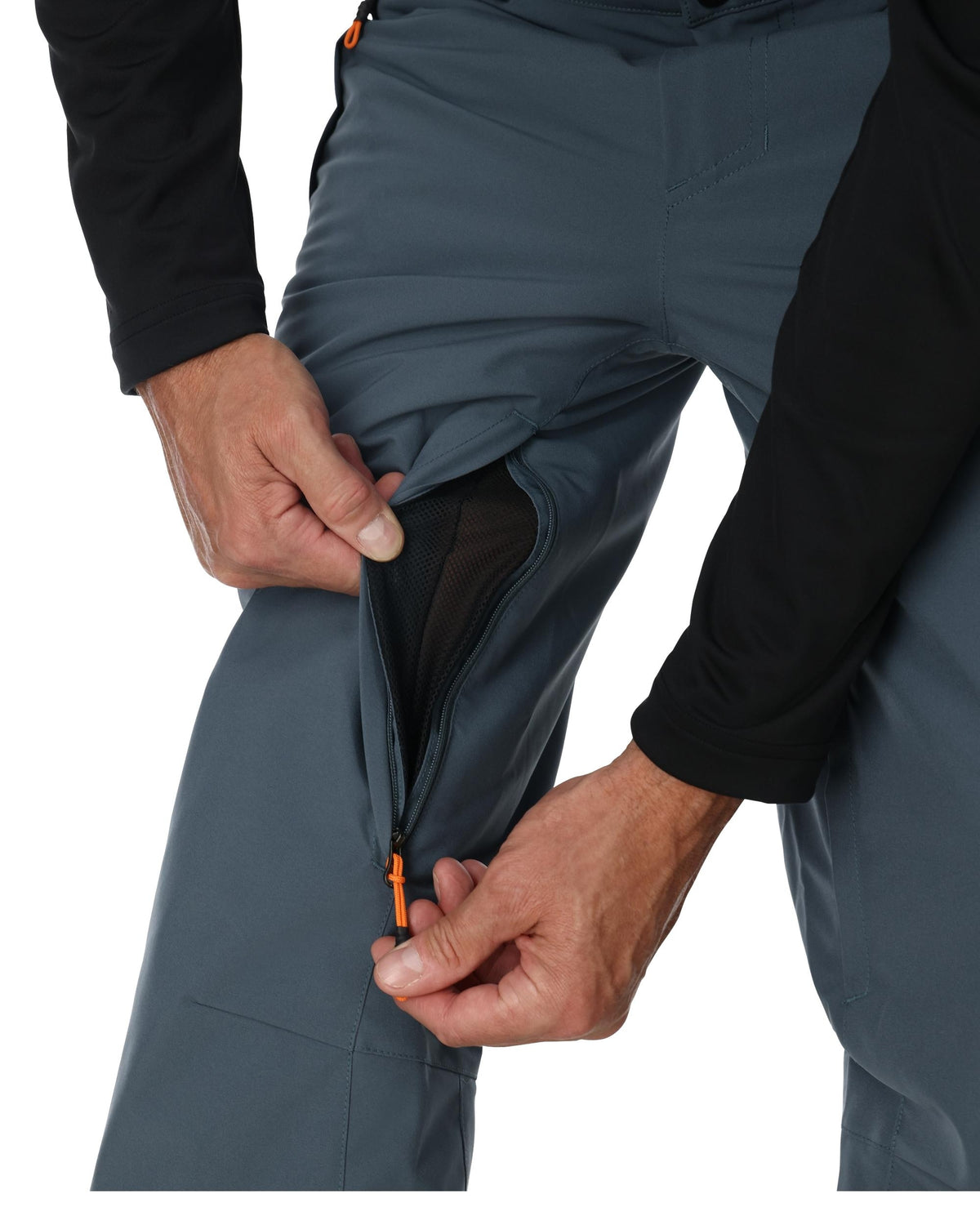 Person adjusting a gray pant with an orange zipper on a white background