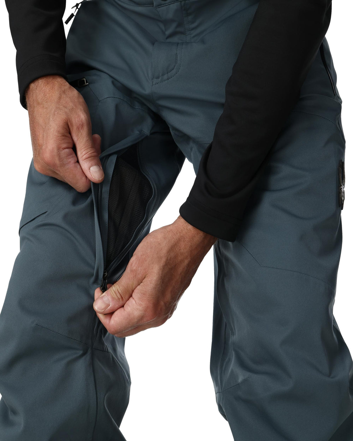 Person adjusting dark gray pants on a white background