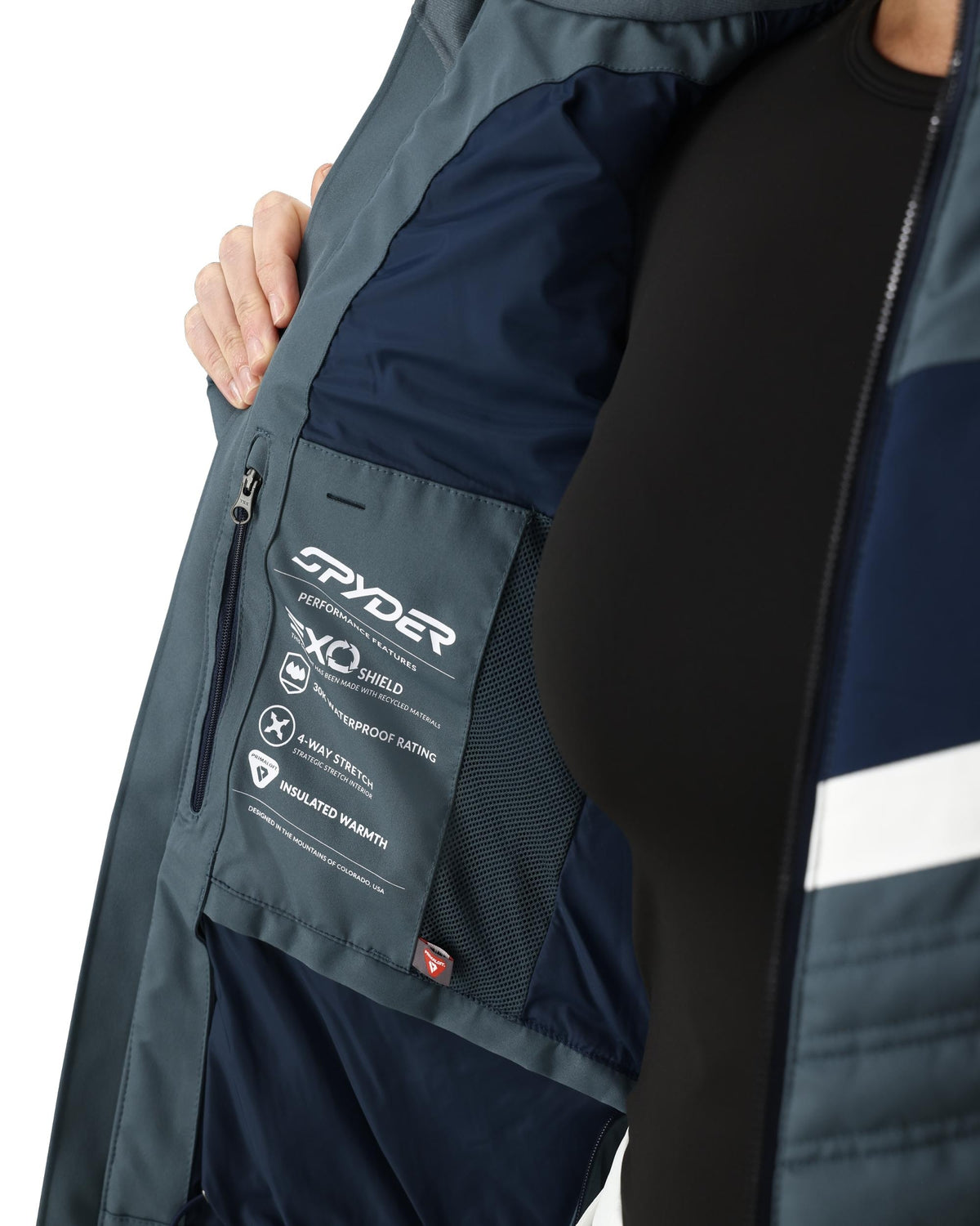 Close-up of a Spyder jacket with visible branding and features on a white background