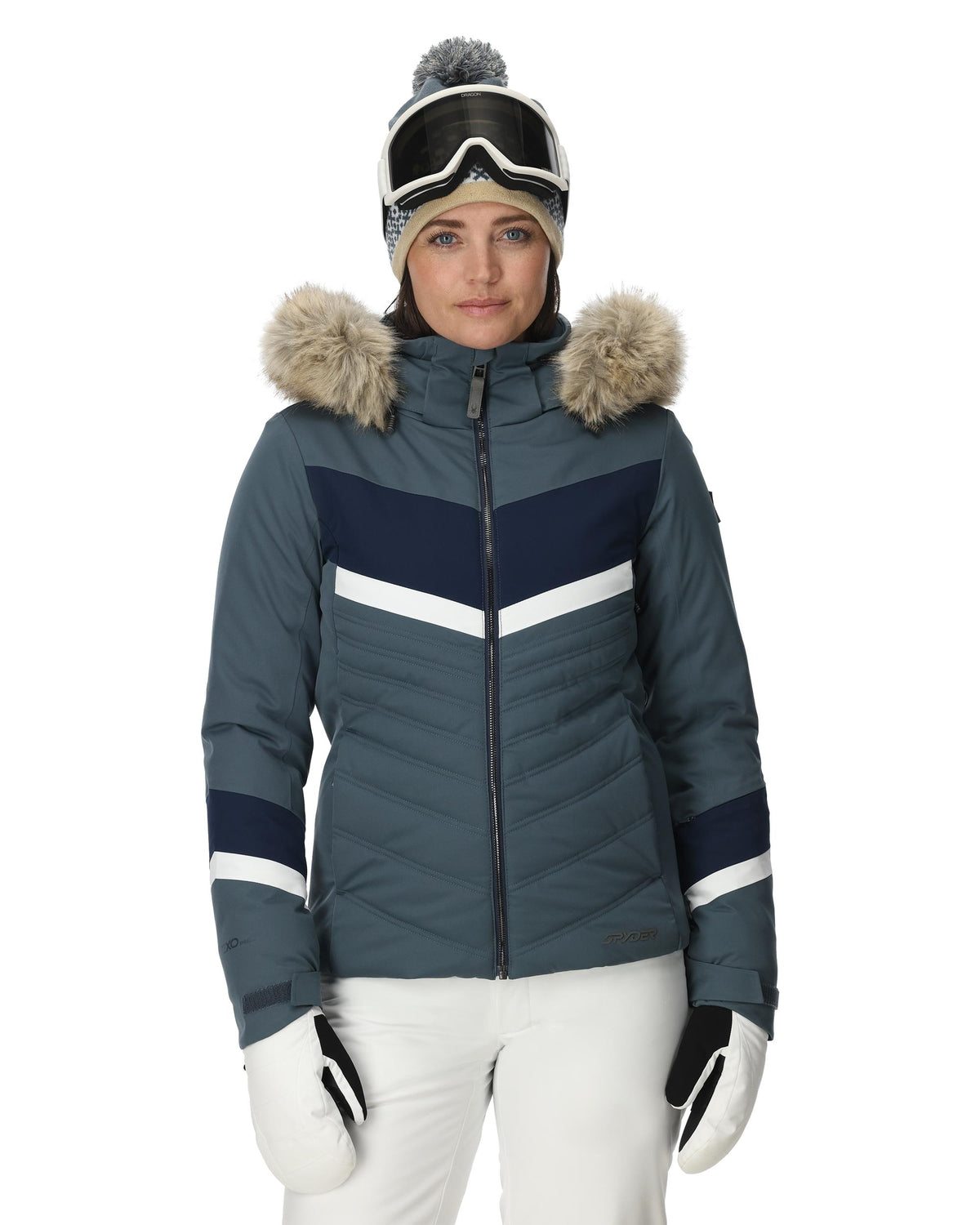 Person wearing a blue and gray winter jacket with fur-lined hood on a white background