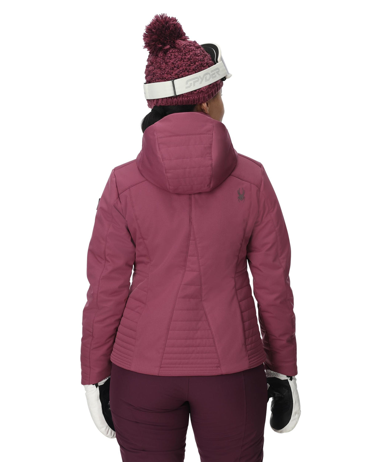 Person wearing a pink winter jacket, pants, and hat on a white background