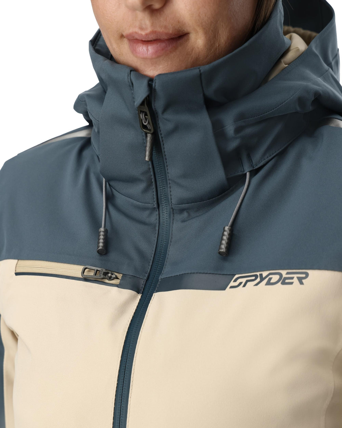 Close-up of a person wearing a blue and beige Spyder jacket.