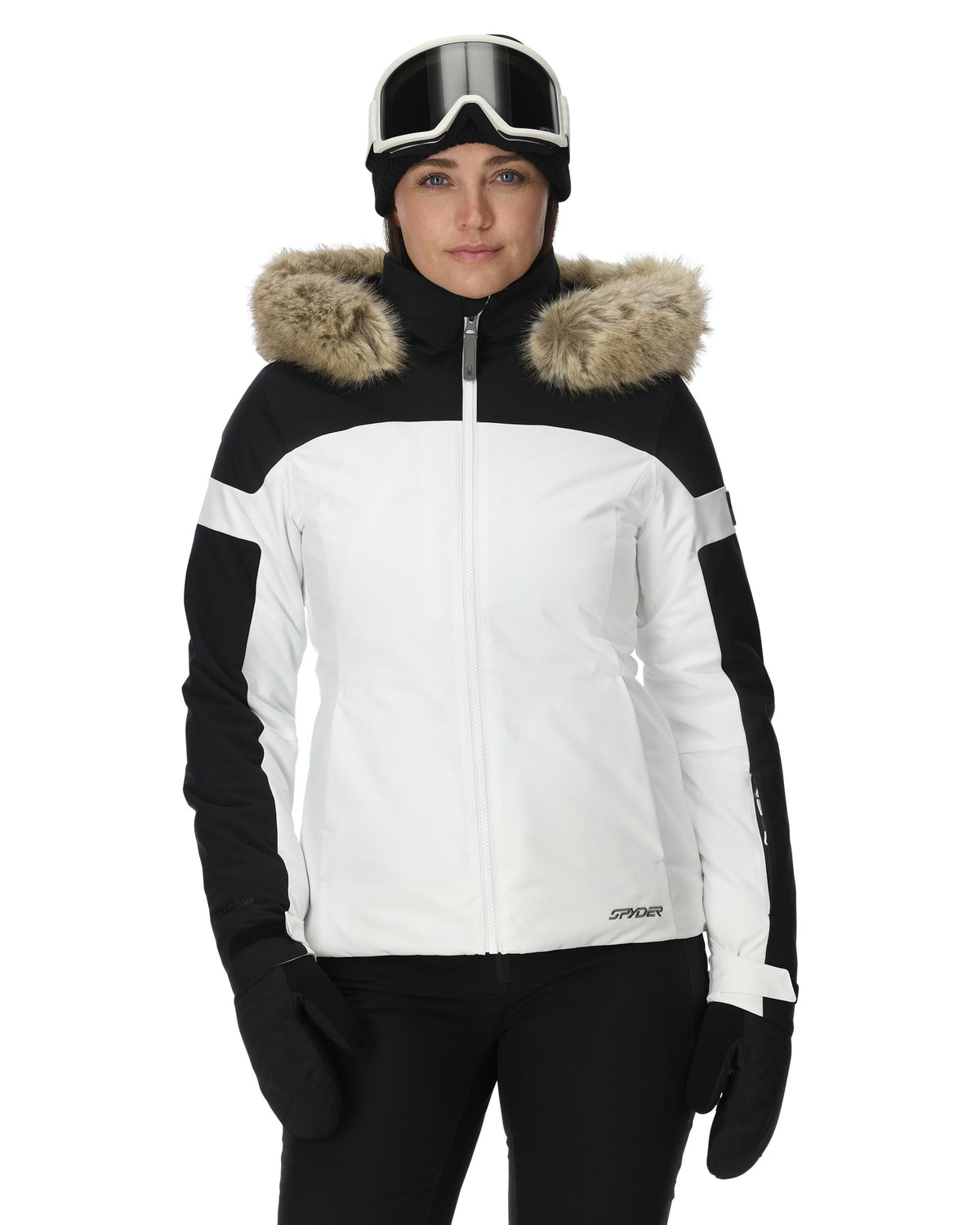 Person wearing a black and white ski jacket with fur-lined hood on a white background