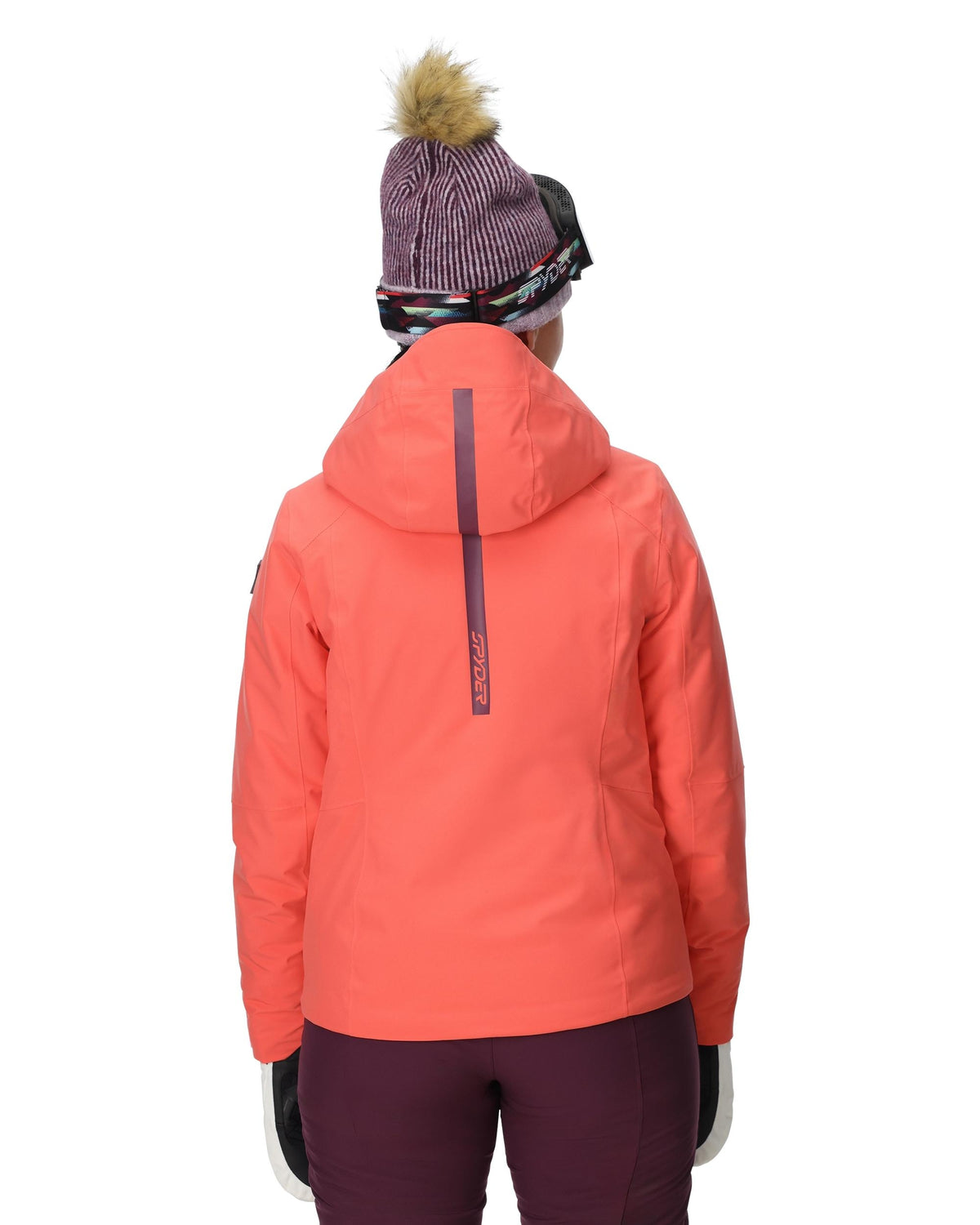 Person wearing a bright orange jacket and maroon pants on a white background