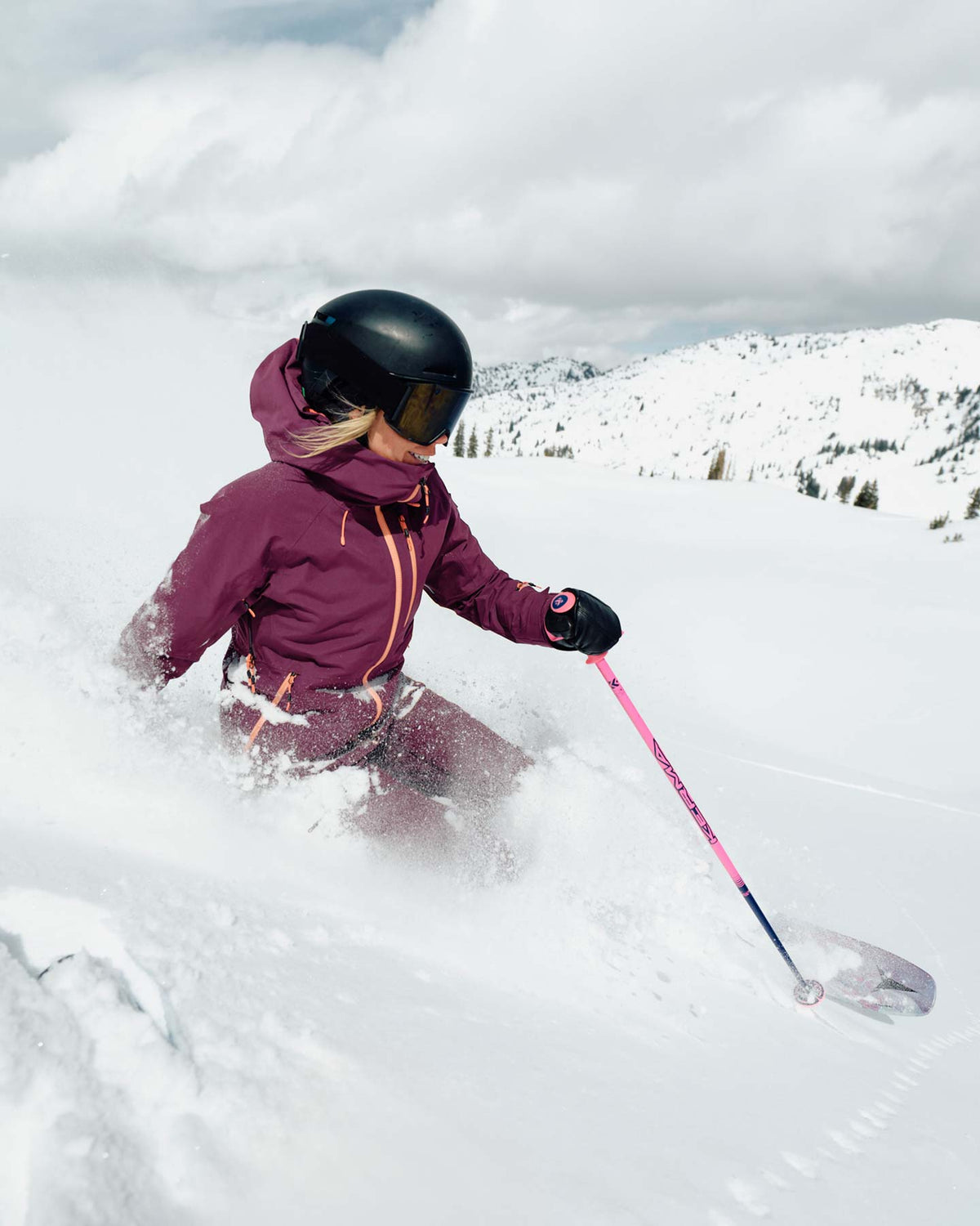 Person skiing in a snowy landscape with a helmet and goggles on.