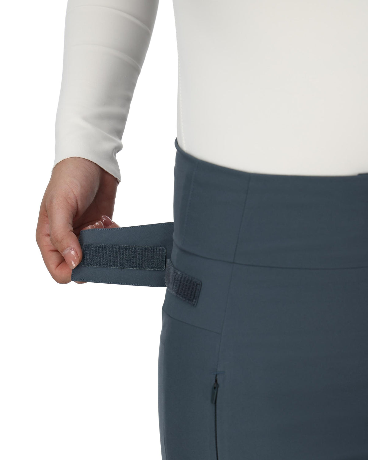Person wearing blue pants with a white shirt, focusing on the waistband.