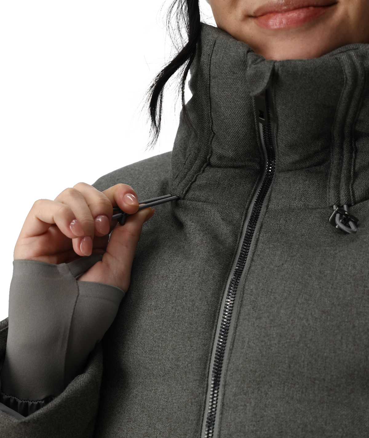 Person wearing a gray jacket with a close-up of the zipper.