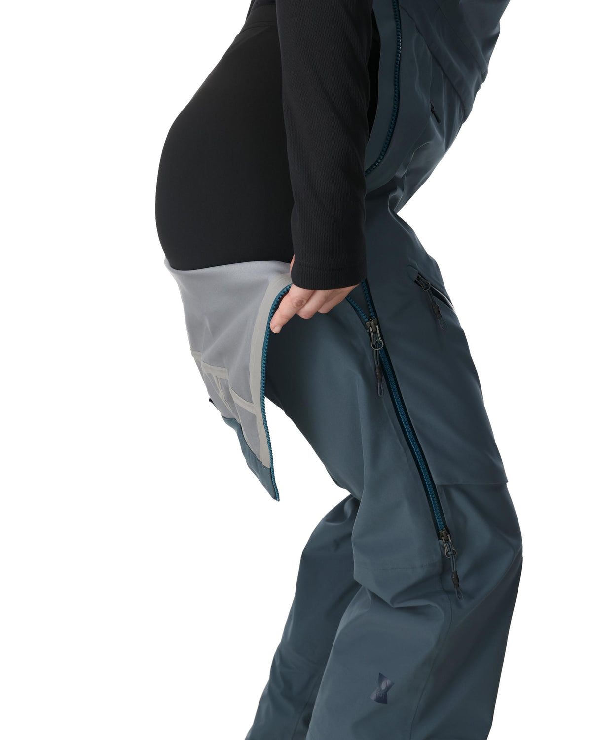 Person wearing a dark gray snow pants with a black jacket on a white background