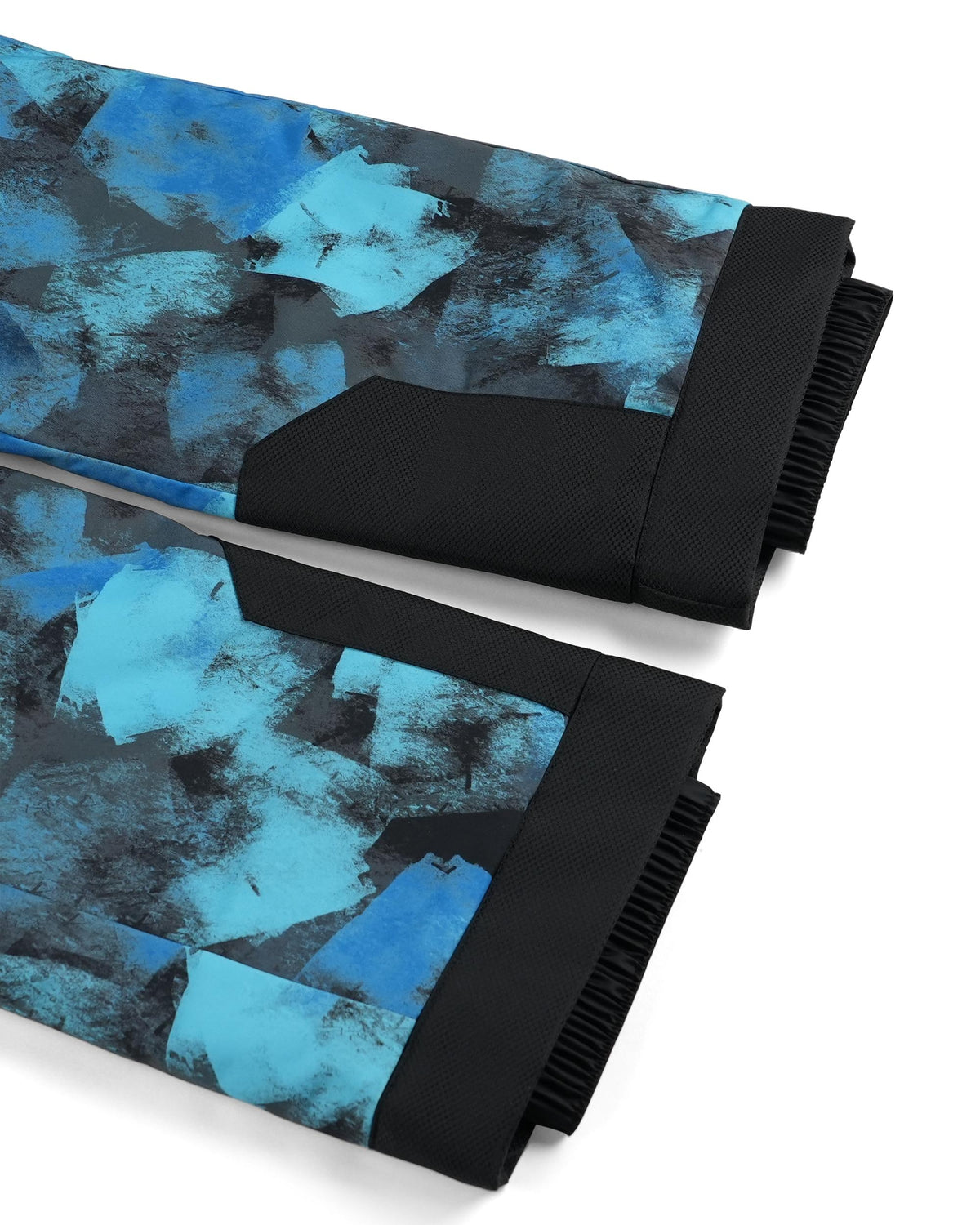 Two folded pant legs with blue and black abstract pattern on a white background