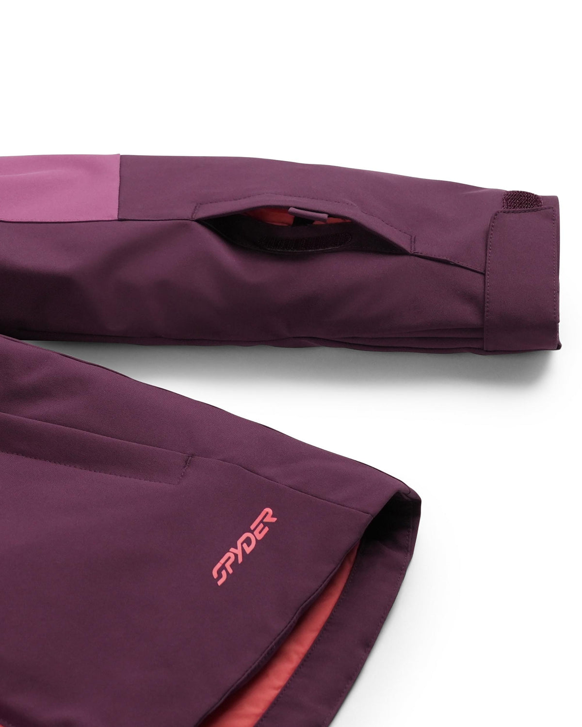 Close-up of a purple jacket with 'Spyder' logo on a white background