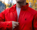 Person wearing a red Spyder Gridweb Performance Fleece, standing in a forest setting.