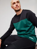 Man wearing a black and green base layer with Spyder logo on a gray background