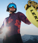 Person in mountainous landscape wearing ski gear with Leki equipment visible