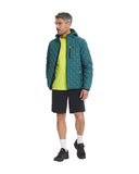 Man wearing a green quilted jacket, yellow shirt, black shorts, and black shoes on a white background