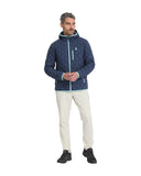 Man wearing a blue quilted jacket and beige pants on a white background