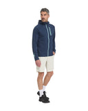 Man wearing a navy hoodie with a brand logo, beige shorts, and black shoes on a white background