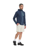 Man wearing a navy blue jacket with a brand logo, white shorts, and black shoes on a white background