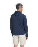 Man wearing a navy hoodie with a logo on the back, standing against a white background