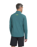 Man wearing a teal jacket with a brand logo on the back, standing against a white background