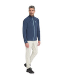 Man wearing a blue jacket and white pants on a white background