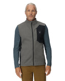 Man wearing a gray and blue jacket with a logo on a white background