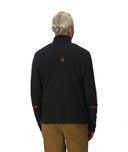 Person wearing a black long-sleeve shirt with a red logo on the back, standing against a white background.