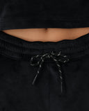 Black drawstring pants with a cropped black top on a plain background