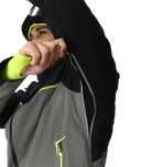 Person wearing a black, gray, and green jacket with a white background