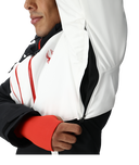 Close-up of a person wearing a white jacket with red accents and a logo.