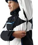 Man wearing a black, white, and blue jacket with a hood.