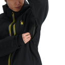 Person wearing a black jacket with yellow accents and a logo on a white background
