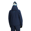 Person wearing a navy blue ski jacket and pants with a matching beanie on a white background