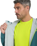 Man wearing a green shirt and gray jacket on a white background