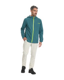 Man wearing a teal jacket with a yellow zipper and white pants on a white background